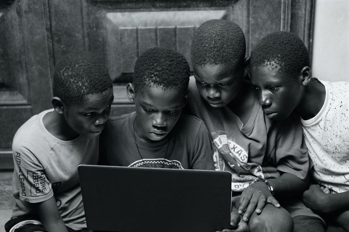 A group of boys using a laptop at home