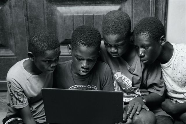 A group of boys using a laptop at home