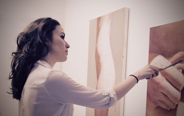 British artist Amy Hughes working on figurative paintings in art studio in Manhattan, New York.